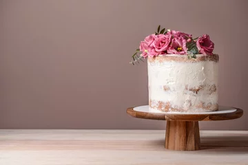 Fotobehang Sweet cake with floral decor on table against color background © Pixel-Shot