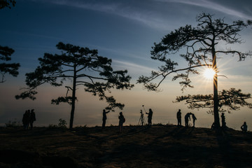 Silhouettes of tourist team on mountain peak