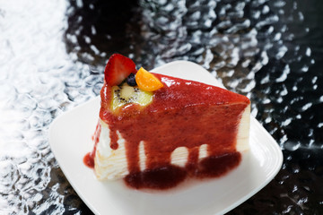 closeup crepe cake with strawberry sauce and mixed fruit