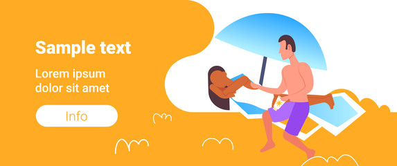 man applying suntan cream to his african american girlfriend sunbathing on beach sunbed sun protection cosmetic summer vacation concept full length horizontal copy space