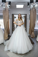 Obraz premium Woman in wedding dress in full length in store