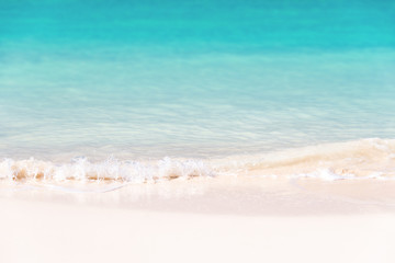 Waves on white sand and turquoise water; summer background