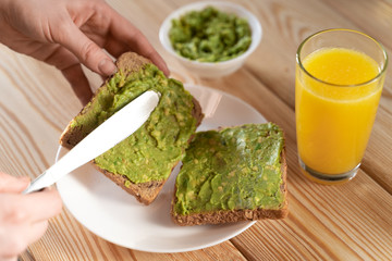 toast bread with guacamole on wooden cutting board - close up