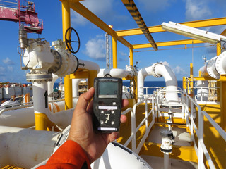 Personal H2S Gas Detector,Check gas leak. Safety concept of safety and security system on offshore oil and gas processing platform, hand hold gas detector. - obrazy, fototapety, plakaty