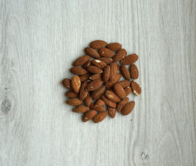 Healthy food  for background image close up almond nuts. Texture on white grey table top view. Nut on the cup plate