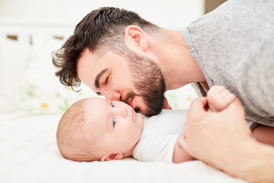 Liebevoller Vater gibt seinem Baby einen Kuss