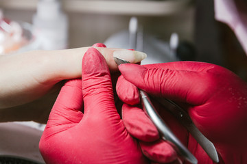 manicurist cuts a cuticle on a female hand beauty care manicure. Selective focus