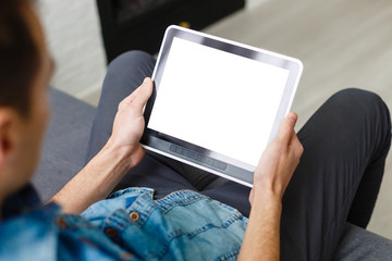 Man using tablet computer while sitting on a wooden floor. View from above. Clipping path included