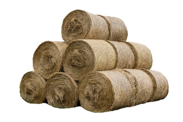 Stacked like a pyramid, bales of straw, tightened mesh . Feed and bedding for livestock on a dairy farm. General view.  Isolated photo .
