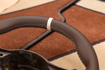 Leather steering wheel brown color in the process of stitching with a bright contrast seam and...