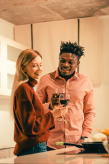 Smiling lady drinking wine with boyfriend in the kitchen