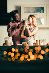 Romantic atmosphere in the kitchen and couple enjoying red wine
