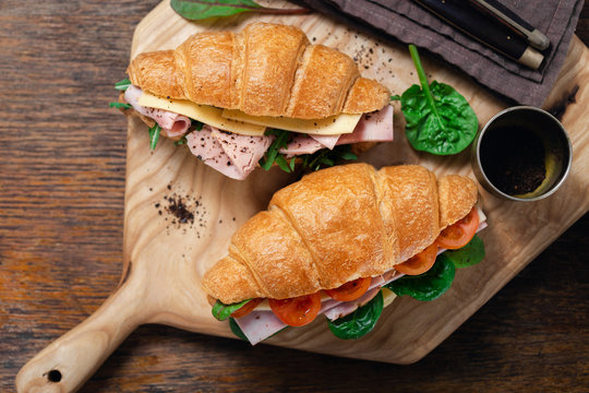 Breakfast croissant sandwiches served wooden board