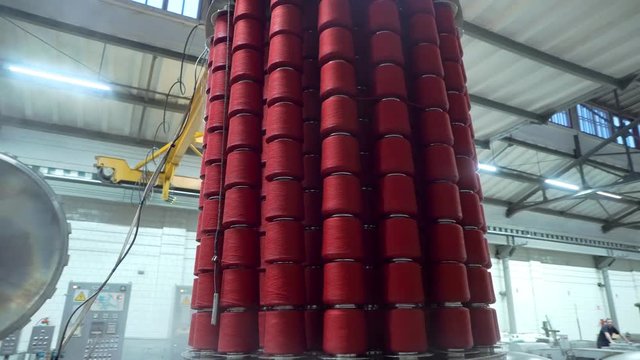 Textile factory female worker works with thread coloring machine. Modern technology in dyeing yarns with Machines for Textile Industry, Dyeing Machine Chemical Tanks