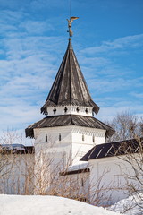 Old white stone fortress tower with angel weather vane