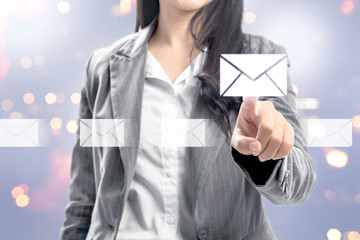 Business woman pointing email icons on virtual screen