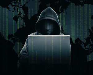 Hacker in black hoodie holding laptop with his hand and world map with binary code