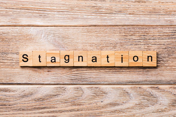 stagnation word written on wood block. stagnation text on wooden table for your desing, concept