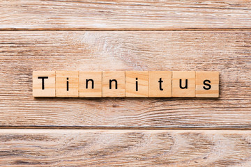 TINNITUS word written on wood block. TINNITUS text on wooden table for your desing, concept