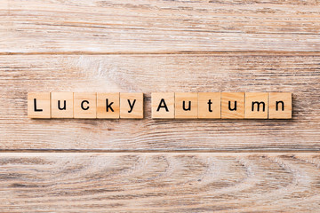Lucky autumn word written on wood block. Lucky autumn text on wooden table for your desing, concept