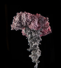 Coloured acrylic ink mixing in water on black