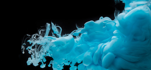 Coloured acrylic ink mixing in water on black