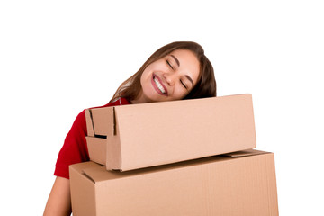 Pretty young woman loves her job. Delivery girl is holding a heap of boxes isolated on white background