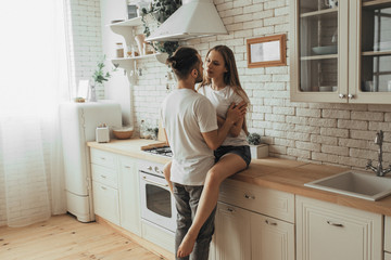 Beautiful loving couple kissing in kitchen