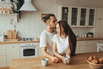 Beautiful loving couple kissing in kitchen