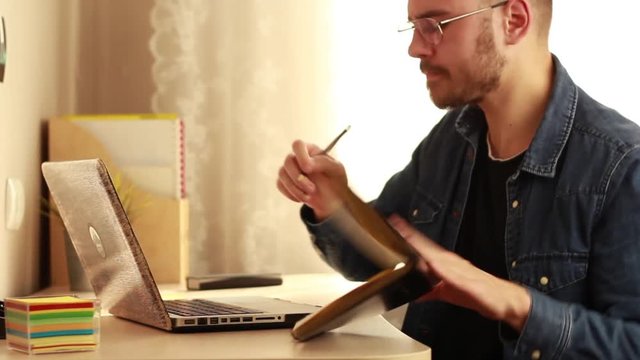 The guy writes in a notebook