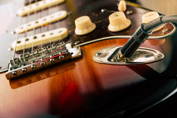 Details and connection of guitar and wire cable jack. Tone and volume controls.