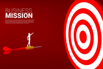 silhouette of businessman standing on arrow dart point forward to dartboard. Business Concept of targeting and customer.Company vision mission.