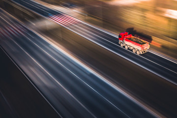 Fototapeta na wymiar Fast tipper red truck - panning by drone