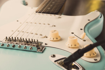 Details and connection of guitar and wire cable jack. Tone and volume controls.
