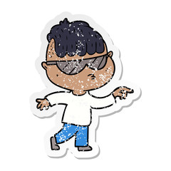 distressed sticker of a cartoon boy wearing sunglasses pointing