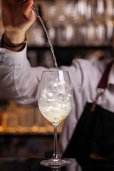 Hugo cocktail drink with ice cubes, mint and lemon