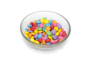 Bright colorful candy in bowl on white background