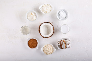 Coconut Products - coconut oil, water, milk, sugar, flakes and flour on white background. Top view.