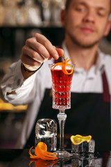 Kir Royal cocktail with orange slice and ice cubes