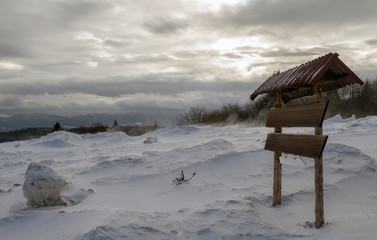 Fototapeta premium Wooden sign on snowy and windy mountain
