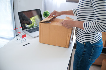 woman preparing package delivery box at home online order shopping.