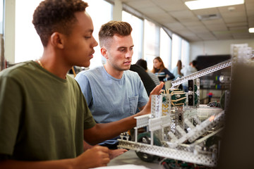Two Male University Students Building Machine In Science Robotics Or Engineering Class