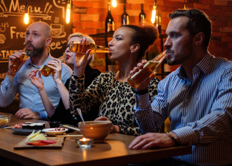 Group of friends watching tv in a cafe behind bar counter