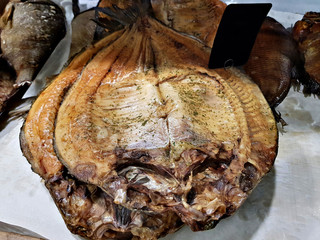 Huge gutted smoked fish with spices on the shop counter
