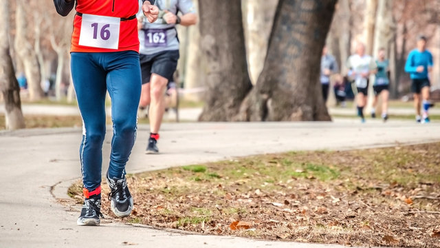 Closeup Of A Runner With Race Number Participating In The Marathon In The Park