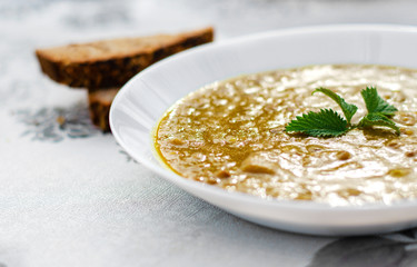 Closeup of lentil soup served in white plate