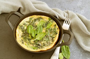 Omelet with spinach in a cast iron pan.