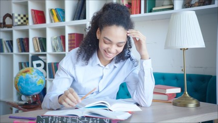 Happy african american student preparing easily for examination in university