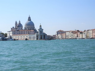 Fototapeta na wymiar Summer day view from the water to the Venetian lagoon with the Basilica of Santa Maria della Salute in Venice, Italy.