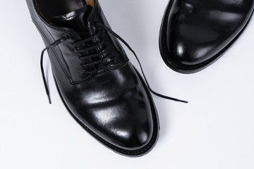 Two classical black leather shoes on white background. Closeup view from above.
